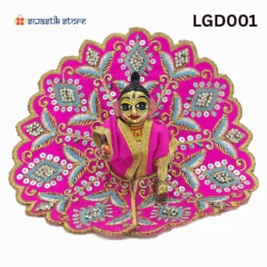 A small, brass Laddu Gopal (baby Krishna) deity idol is seated and dressed in a vibrant pink poshak (outfit). The outfit is heavily adorned with intricate gold embroidery, silver sequins arranged in diamond patterns, and light blue leaf-like designs. The deity has large, expressive eyes and a tilak on the forehead. The background is plain white, with a "Swastik Store" logo in the top left corner and the product code "LGD001" in the top right. - Swastik Store